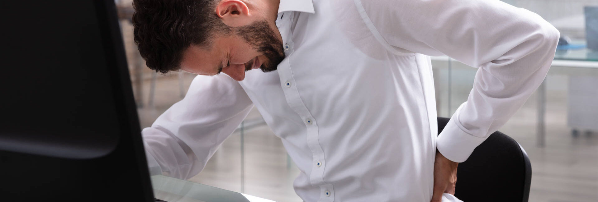 Young Businessman Suffering From Back Pain At Workplace